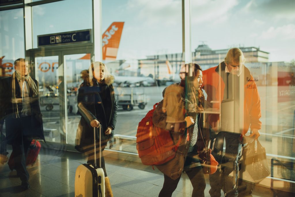 people holding suitcases in airport terminal