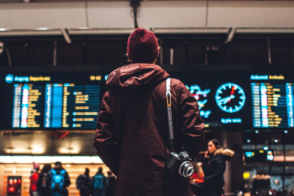 man looking at train timetable in a station