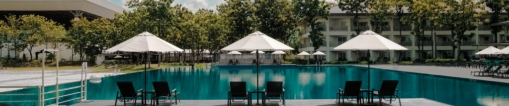 wide shot of a hotel pool area with chairs and umbrellas