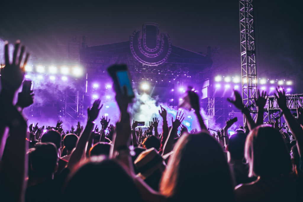 people holding up their hands at a festival