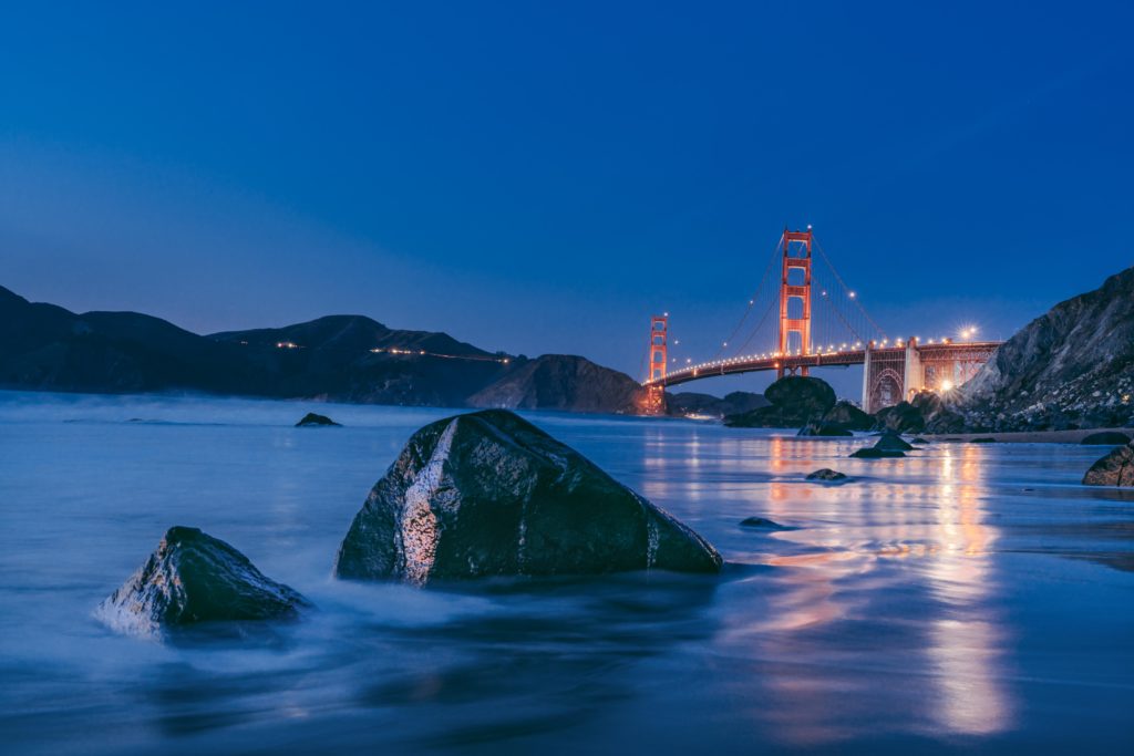 rocks in the sea with golden gate bridge in background