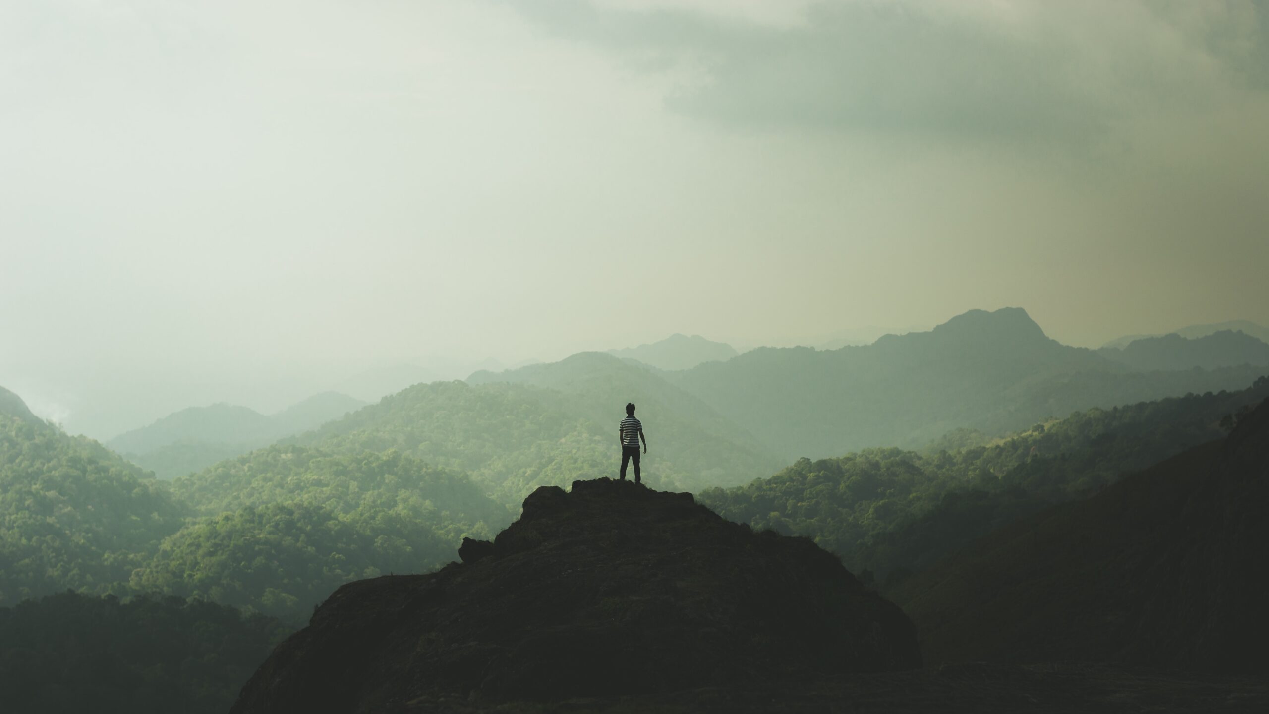 man standing on mountain facing horizon sustainable hospitality alliance